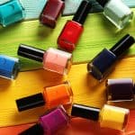 Bottles of nail polish on a colorful wooden table