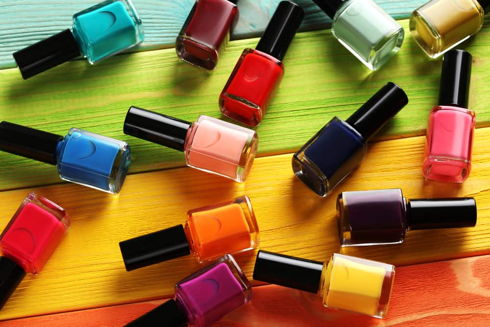 Bottles of nail polish on a colorful wooden table