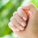 Broken nail on a woman's hand with a manicure