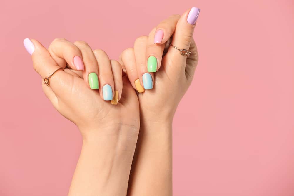 Hands of young woman with beautiful manicure on color background