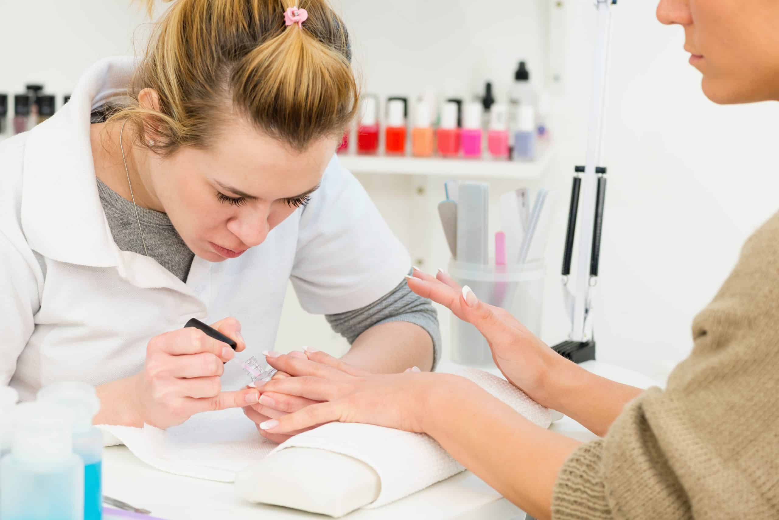 Manicurist working with client