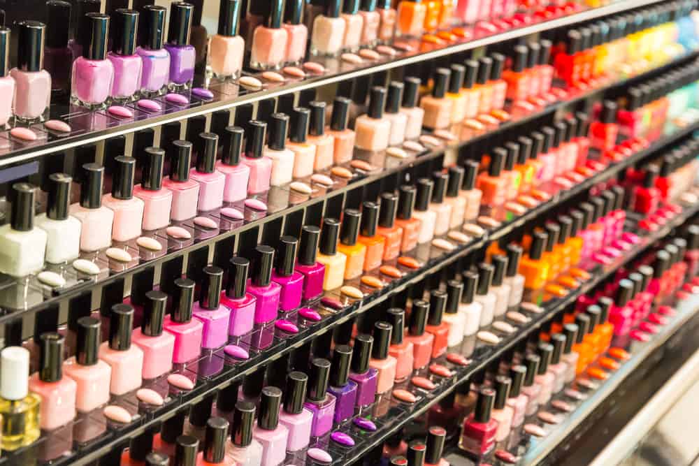 Set of different nail varnishes on shelves in cosmetic store