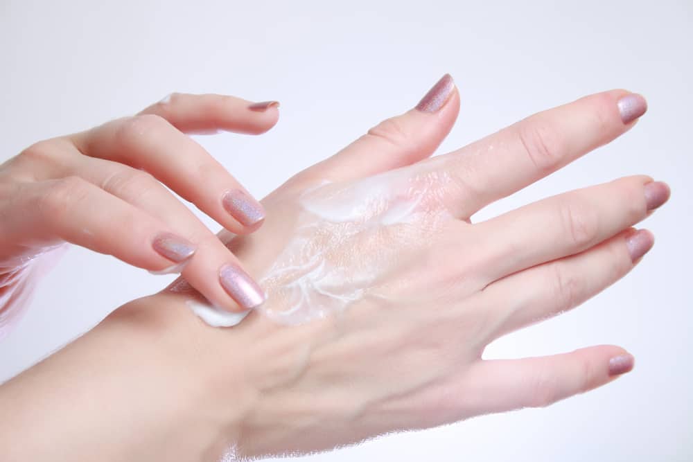 Woman applying moisturizing cosmetic creams