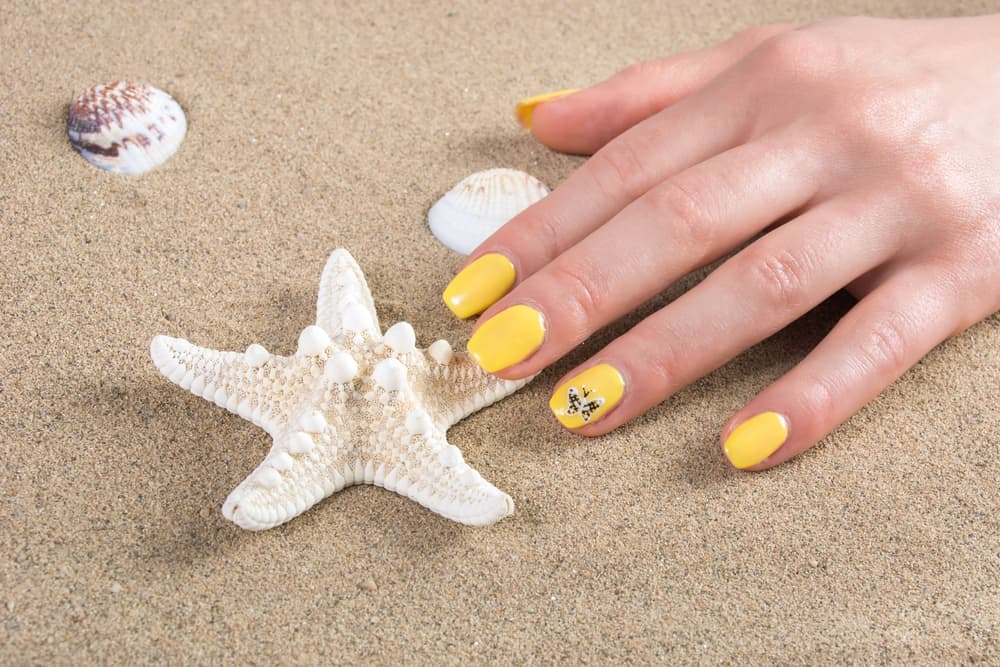 Woman with yellow nails manicure polish