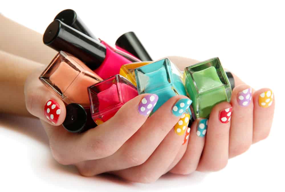 woman hands with nail polishes isolated on white