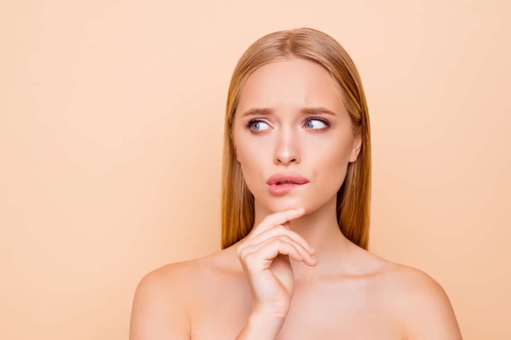 woman holding hand on chin looking to the side