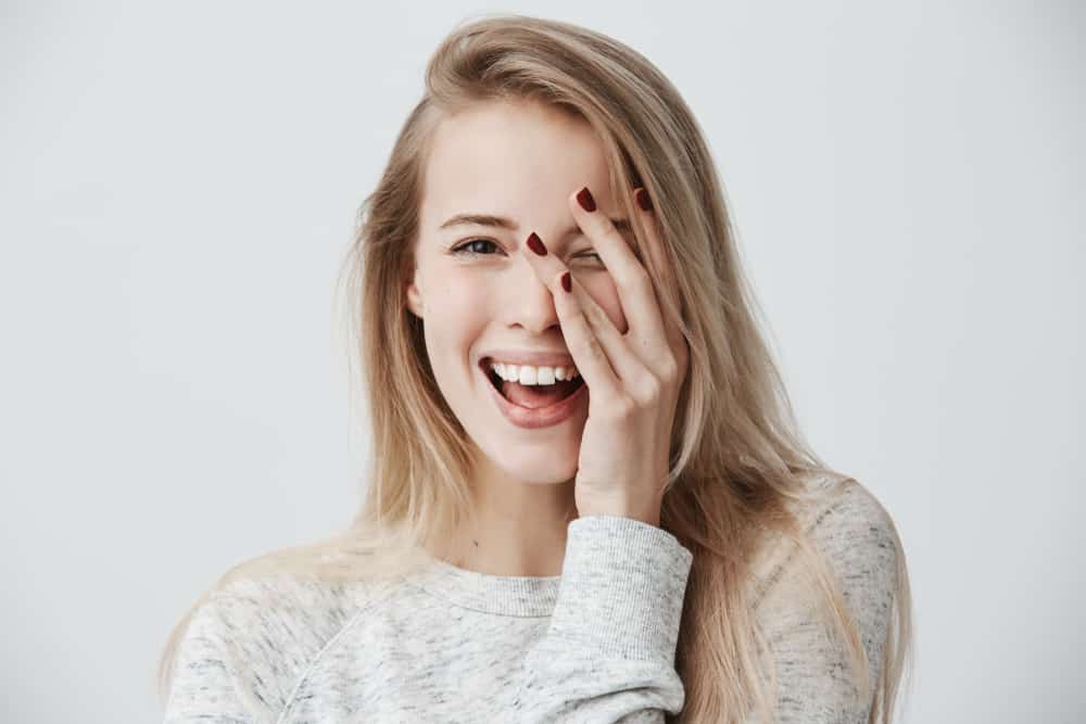 woman with dark eyes, blonde long hair, happy gentle smile