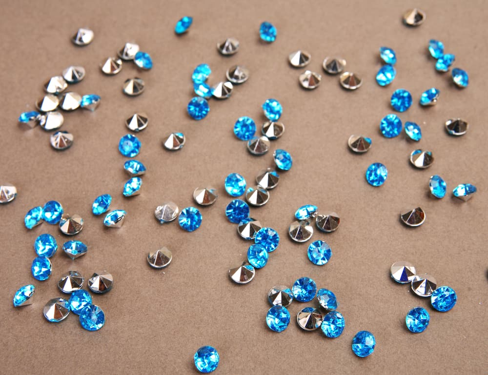 Blue shiny stones scattered on beige background