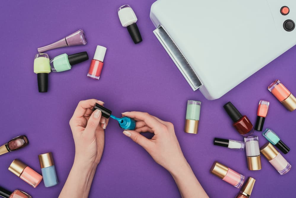 Cropped image of woman holding turquoise nail polish