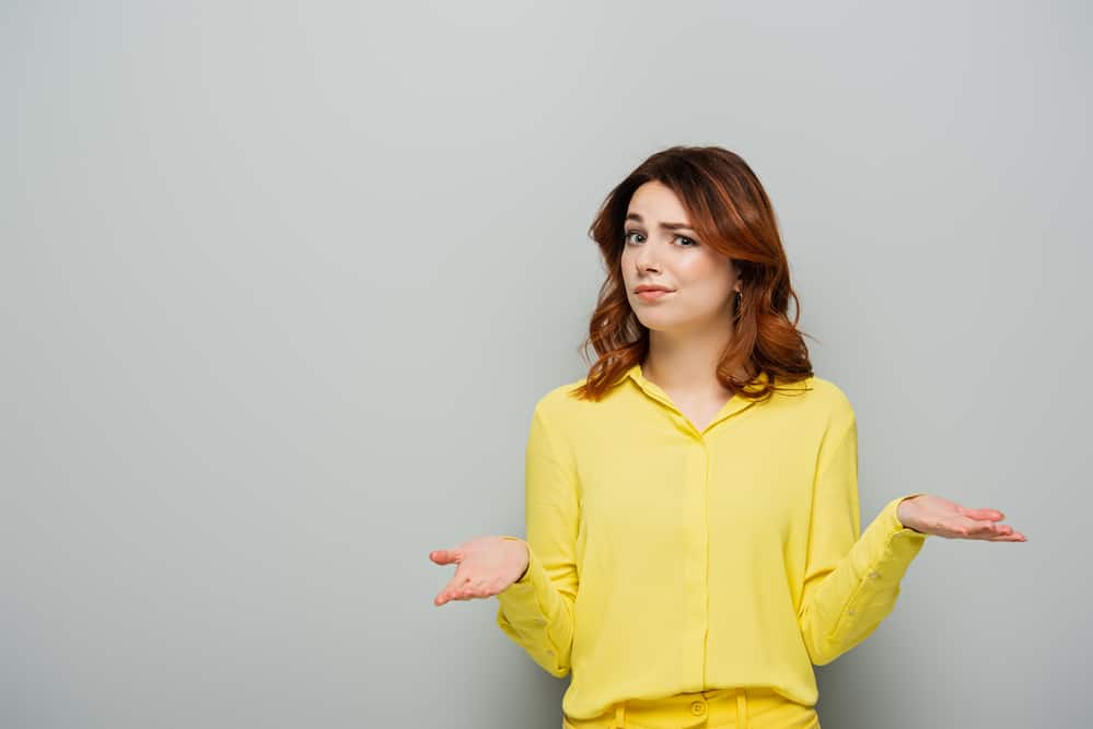 Displeased woman showing shrug gesture