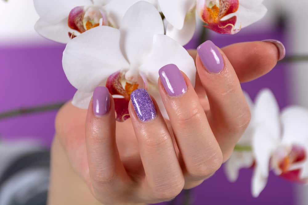 Female hand with a lilac color nails polish gel