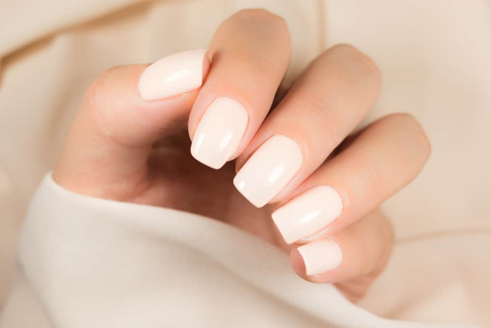 Light manicure in light on a pink background