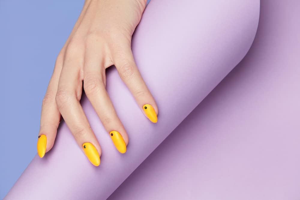 Nails Design. Hands With Bright Yellow Manicure