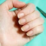 Uneven nails on women's hands that are crooked with scissors