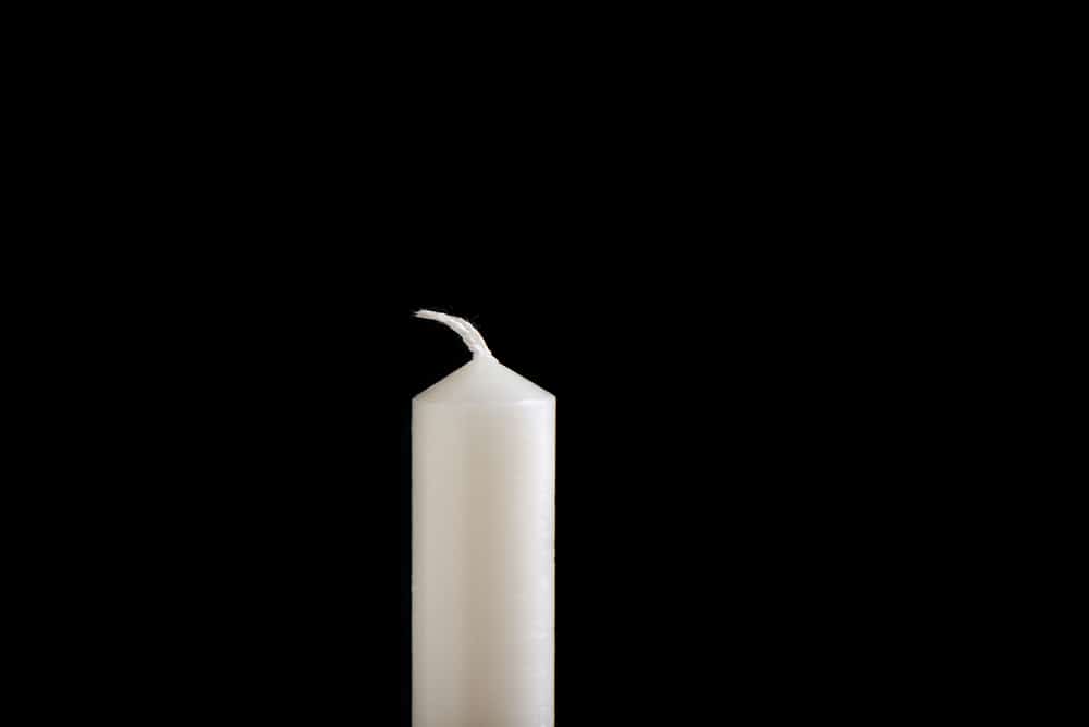 White unlit candle isolated on white background