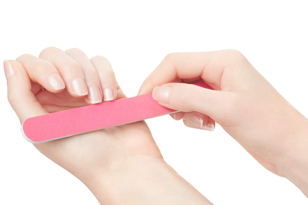 Woman hands manicure with nail file isolated on white, clipping path included