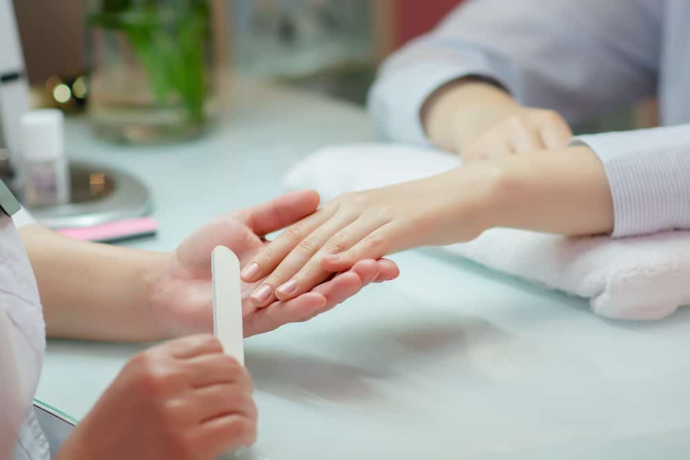 Woman hands receiving a manicure in beauty salon