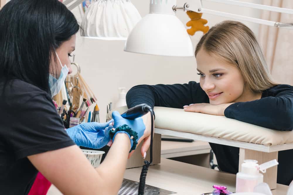 girl smiles at the manicure master in a cozy nail salon