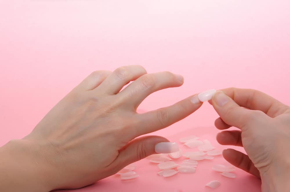 woman hands taking care of false nails