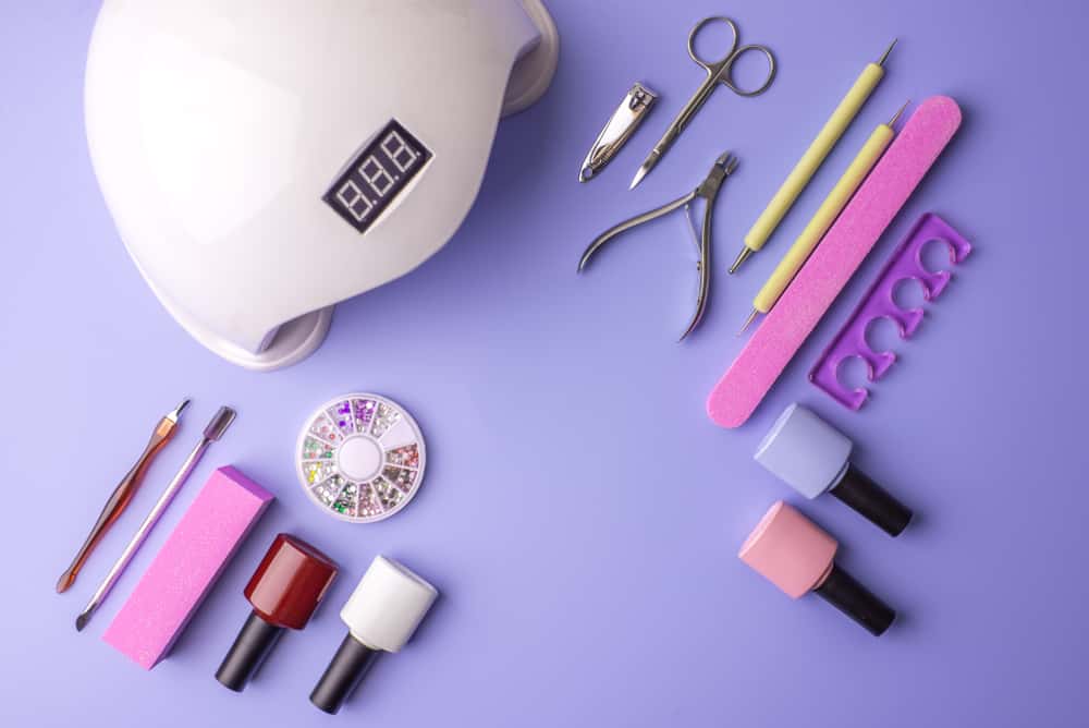 A set of cosmetic tools for manicure and pedicure on a purple background