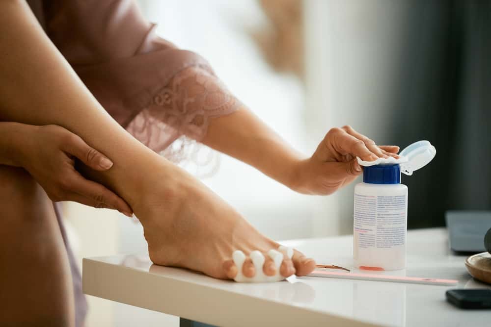 Close-up of woman using acetone while doing pedicure at home