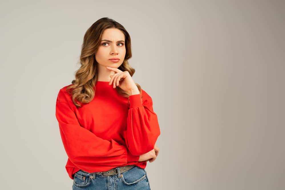 Pensive woman in red sweatshirt looking away and thinking