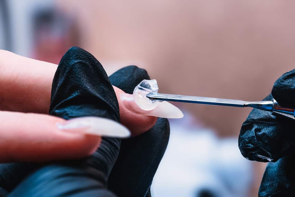 The manicure master applies a base layer of Poly-gel