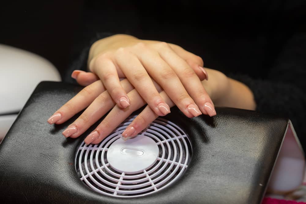 Women hands crossed in nail salon polygel